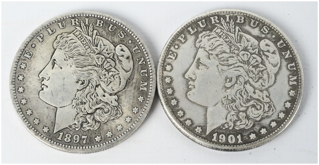A Pair of US Morgan Silver Dollars, 1897-O and 1901-O: This lot consists of two US silver dollars featuring the Morgan Head obverse and the heraldic eagle reverse. Both coins were struck at the New Orleans Mint, indicated by the O mint mark located on the
