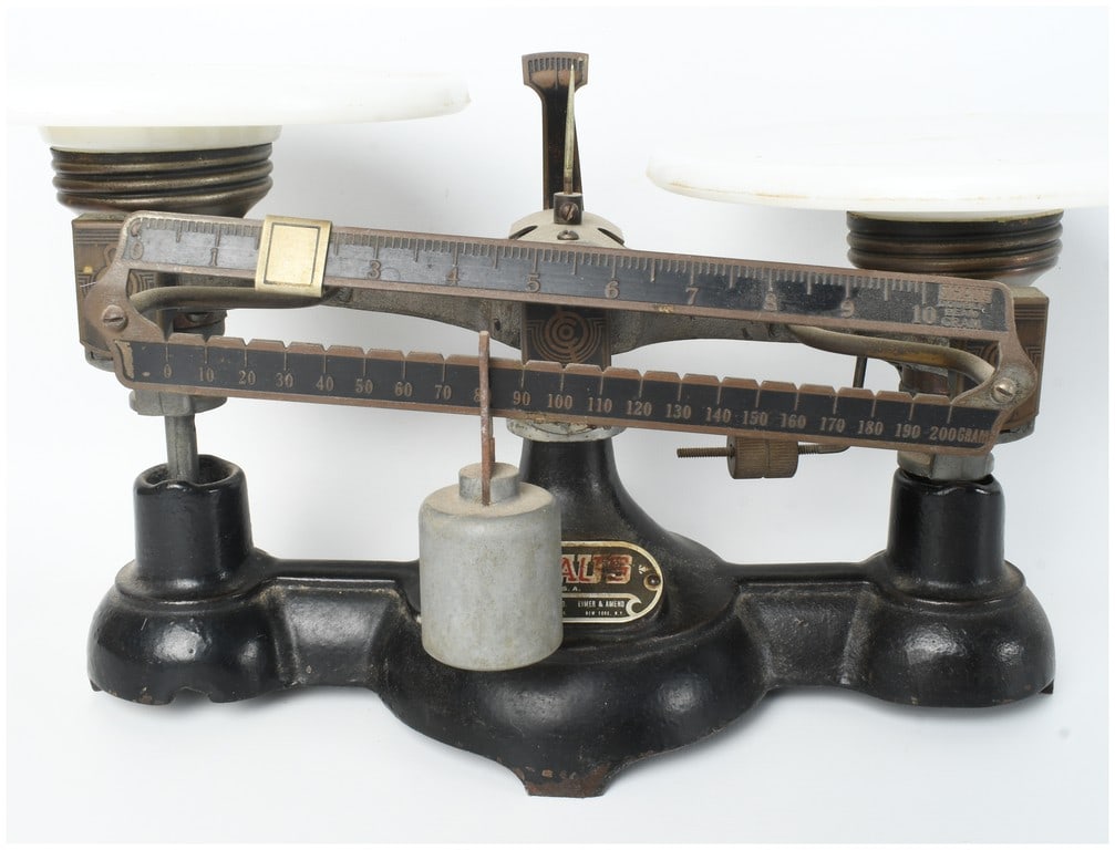 Ohaus Double Beam Laboratory Balance Scale with Milk Glass Pans: This is a vintage laboratory or pharmaceutical double beam balance scale manufactured by Ohaus. The instrument features a heavy cast iron base finished in black paint and two circular white milk glass