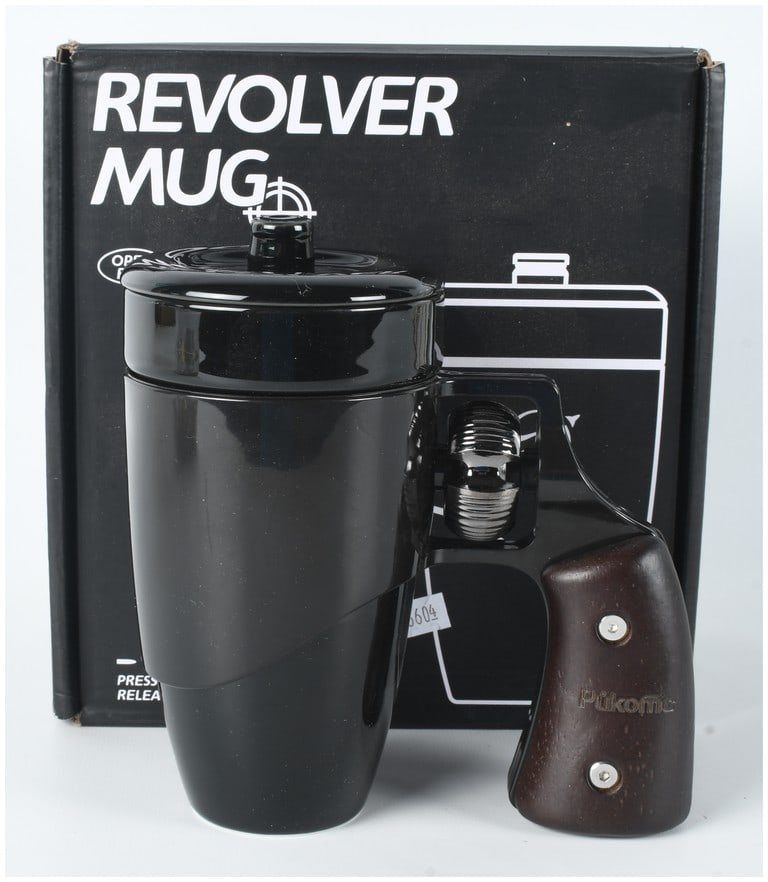 Pukomc Ceramic Revolver Mug with Original Box: A novelty ceramic travel-style mug manufactured by Pukomc. The item features a tapered body and matching lid finished in a glossy black glaze. The handle assembly is designed to resemble the frame and