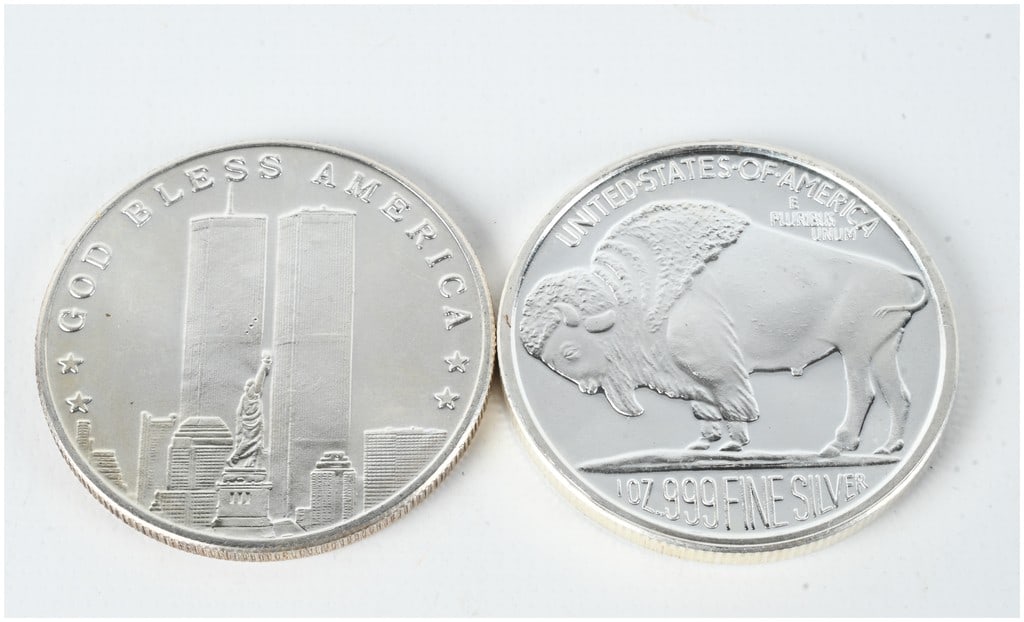 A Pair of 1 oz t .999 Fine Silver Bullion Rounds, Buffalo and 9/11 Designs: A pair of private mint silver rounds, each containing 1 troy ounce of .999 fine silver. The first round commemorates the events of September 11, 2001. The obverse side depicts the World Trade Center T