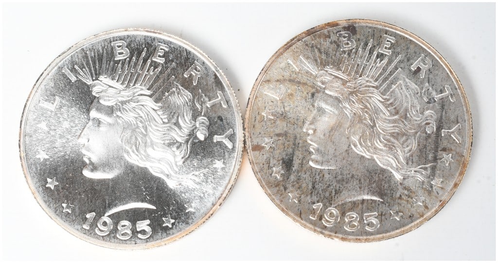 A Pair of 1985 Peace Dollar Design Silver Trade Units: This lot consists of two silver rounds, each containing one troy ounce of .999 fine silver. These are private mint bullion pieces issued under the Silver Trade Unit designation. The obverse features a