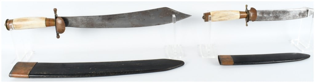 A Pair of German Hunting Knives with Scabbards: This set comprises two German-style hunting knives, traditionally known as Hirschfanger, featuring a larger hunting hanger and a smaller secondary knife. Both weapons possess slightly curved, single-e