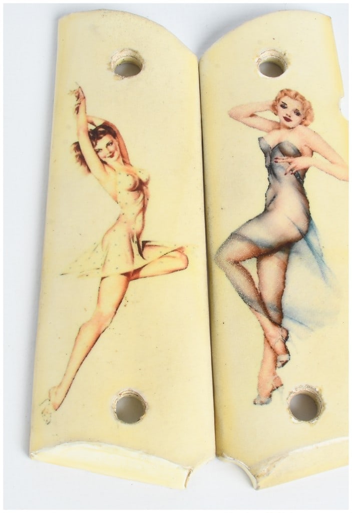 One Pair of 1911-Style Synthetic Ivory Grips with Pin-Up Artwork: This lot consists of one pair of full-size Model 1911-style handgun grips manufactured from a cream-colored synthetic material designed to simulate ivory. The front of each grip features printed vinta