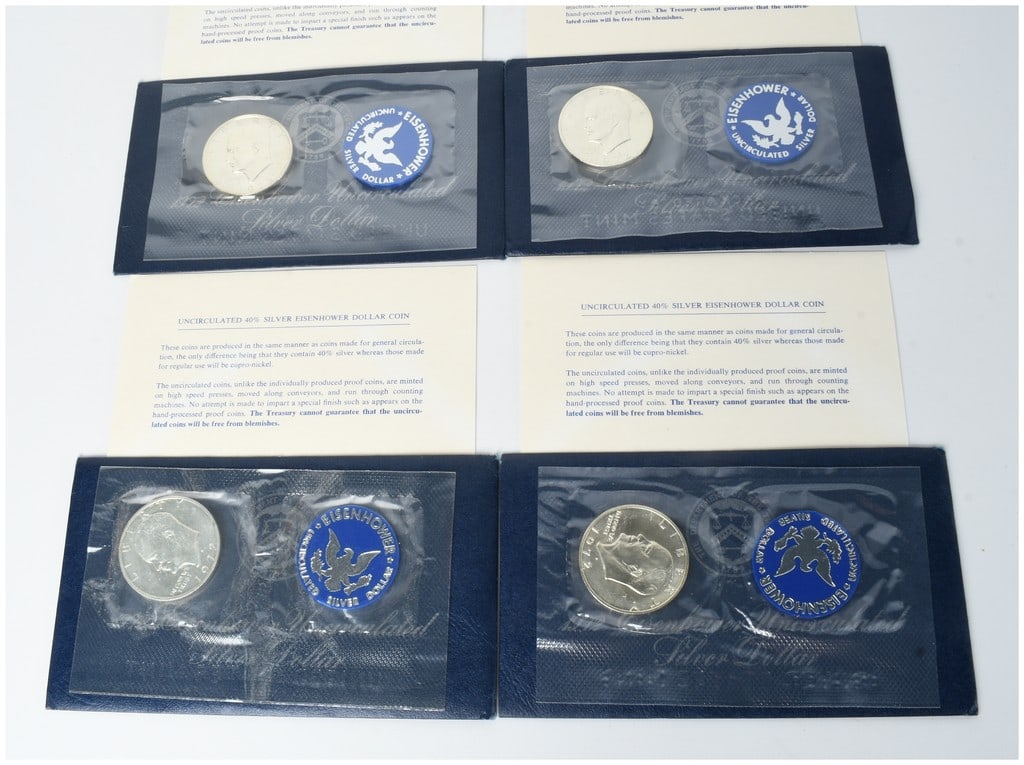 Four US 1972-S Eisenhower 40% Silver Dollar Blue Pack Coins: A lot of four US 1972-S Eisenhower Dollars, struck in 40% silver at the San Francisco Mint. These coins were issued by the United States Mint as uncirculated specimens, commonly referred to as Blue Ik