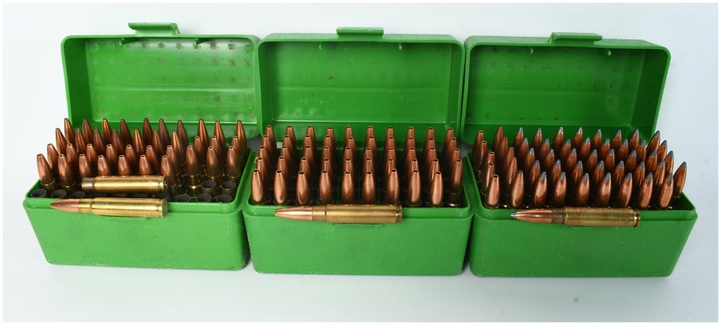 A Lot of 138 Rounds of 7mm TC/U Ammunition and 13 Empty Brass Casings: This lot comprises a collection of 138 rounds of 7mm TC/U ammunition and 13 empty brass casings, organized within three green plastic flip-top storage boxes. The ammunition appears to be hand-loaded a