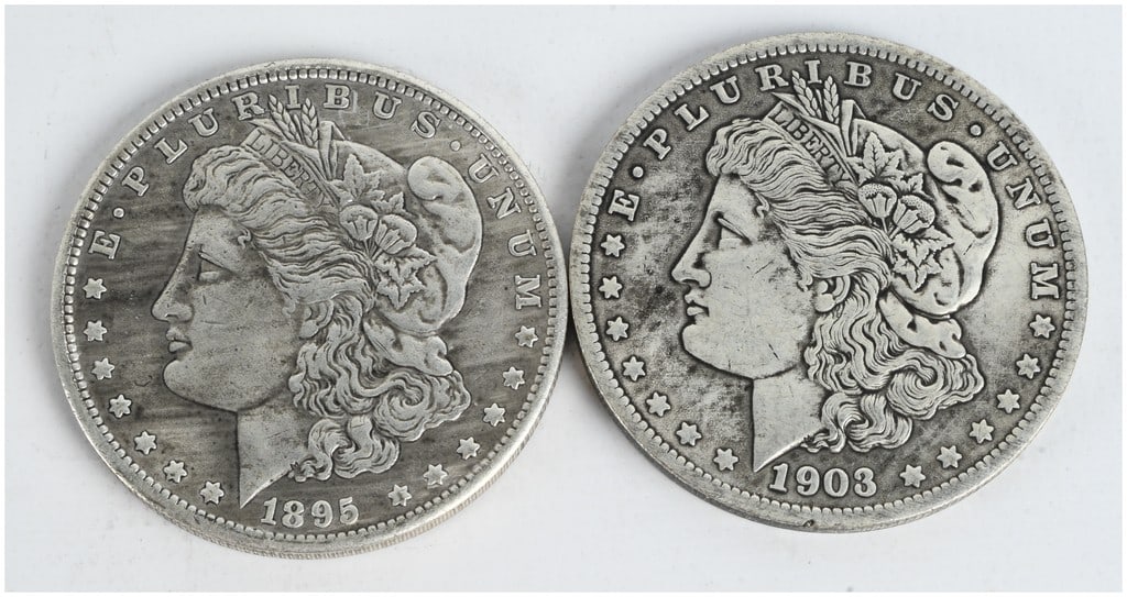 A Pair of US 1895-O and 1903-O Morgan Silver Dollars: A pair of US Morgan Silver Dollars minted at the New Orleans Mint, dated 1895 and 1903 (KM# 110). These coins are struck in 90% silver and 10% copper. Each piece features the Liberty Head design on th
