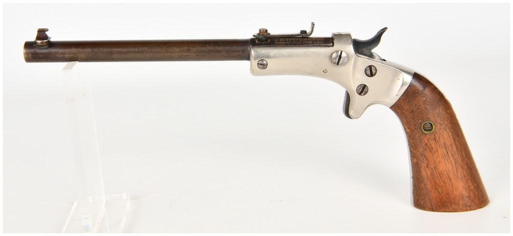 J. Stevens Model 43 Diamond Tip-Up Single Shot Pistol .22 with 10 Inch Barrel: A J. Stevens Arms & Tool Co. Model 43 Diamond Model tip-up single-shot pistol chambered in .22 caliber, intended for target or gallery use. The firearm features a 10-inch round barrel with a dark brow