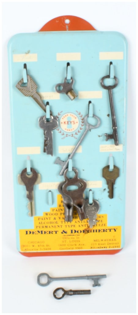 DeMert and Dougherty Inc. Advertising Key Rack with an Assortment of Keys: This vintage advertising key rack was manufactured for DeMert and Dougherty, Inc., a company with listed offices in Chicago, St. Louis, and Milwaukee. The rectangular rack is constructed from painted 