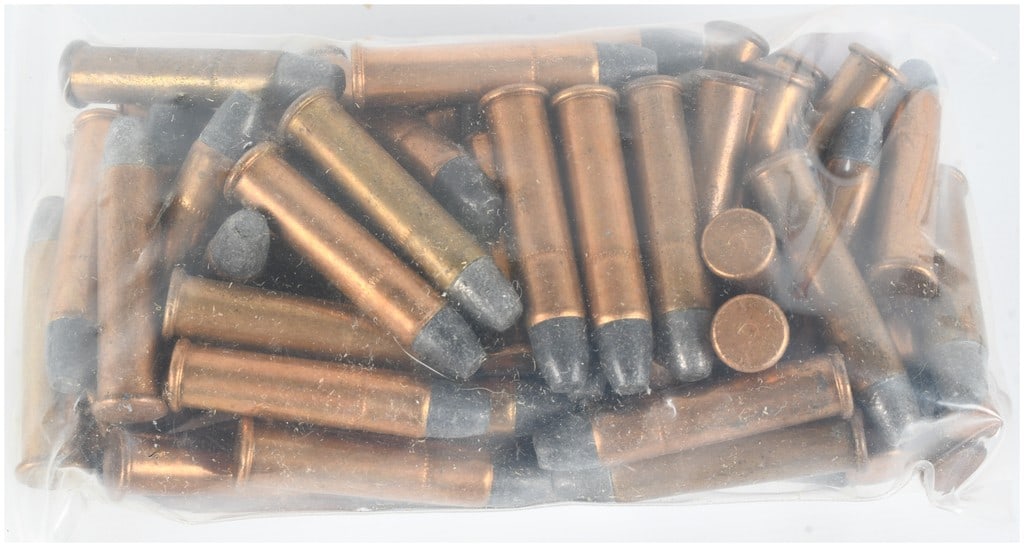 A Lot of 71 Remington-UMC .25 Stevens Rimfire Cartridges: This lot consists of 71 rounds of .25 Stevens rimfire ammunition, featuring copper-toned cases and lead round-nose projectiles. The cartridges are primarily identified by a stylized U headstamp, which