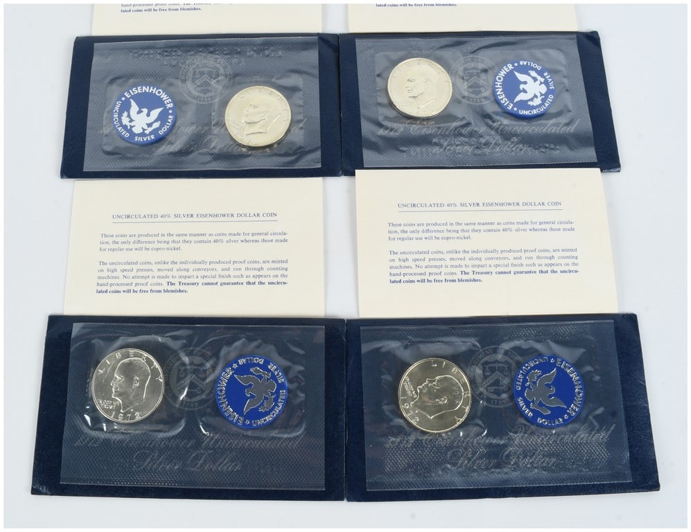 A Set of Four US 1972-S Eisenhower 40% Silver Dollars, Uncirculated Blue Packs: This lot comprises four 1972-S Eisenhower silver dollar coins, struck by the US Mint in San Francisco. Each coin is composed of 40% silver and is presented in its original government uncirculated pack
