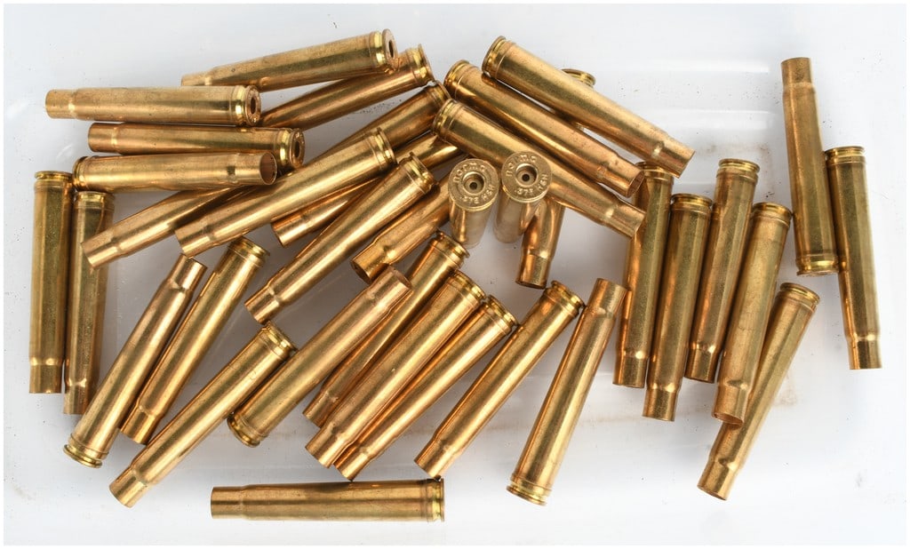 A Lot of 36 Norma Empty Brass Casings .375 H&H Magnum: This lot consists of 36 individual empty brass casings for the .375 Holland & Holland Magnum caliber. Manufactured by Norma, these casings are presented in a fired, uncleaned state with the primers re