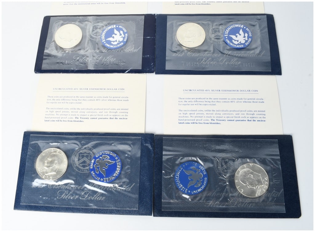 A Set of Four US 1971-S through 1974-S Eisenhower Uncirculated 40% Silver Dollars in Original Blue: This lot comprises four US Eisenhower Dollar coins dated 1971, 1972, 1973, and 1974. Each coin bears the S mint mark signifying production at the San Francisco Mint. These are the 40% silver uncircula
