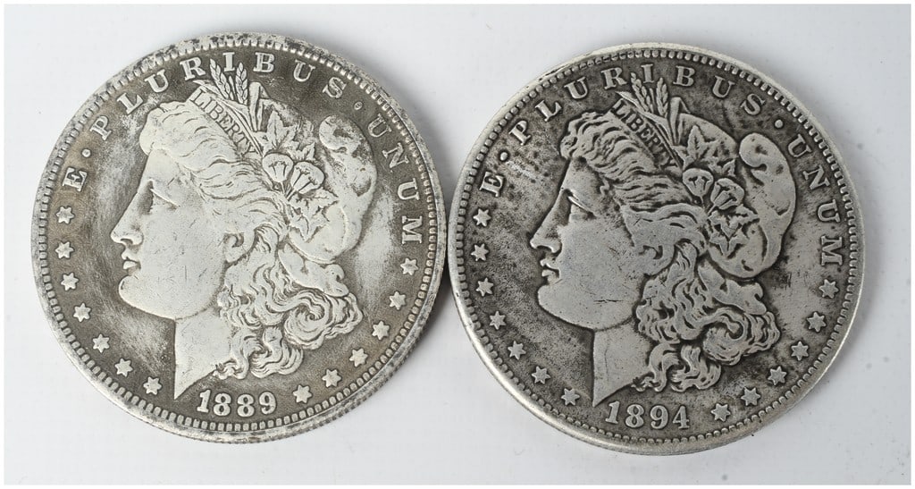 A Pair of US Morgan Silver Dollars, 1889 and 1894-O: A pair of US Morgan silver dollars (KM# 110) struck in 90% silver and 10% copper. The lot includes one 1889 specimen produced at the Philadelphia Mint (no mint mark) and one 1894 specimen bearing the 