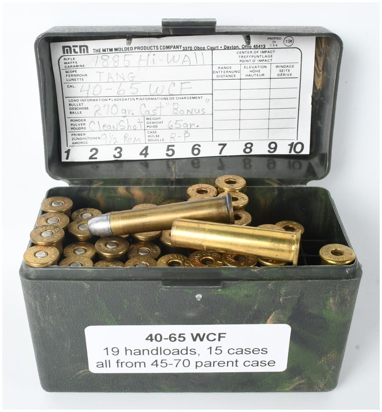 A Lot of 19 Live Rounds and 15 Empty Brass Casings of .40-65 WCF Ammunition: This lot consists of a collection of 34 ammunition components for the .40-65 WCF caliber, comprised of 19 live handloaded cartridges and 15 empty brass casings. The items are housed in a green camoufl
