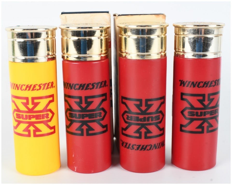 Set of Four Vintage Avon Good Shot Winchester Super X Shotgun Shell Aftershave Bottles with Boxes: This lot features a set of four vintage novelty aftershave bottles manufactured by Avon Products, Inc. under license from Winchester. Designed as oversized 12-gauge shotgun shells, the collection incl