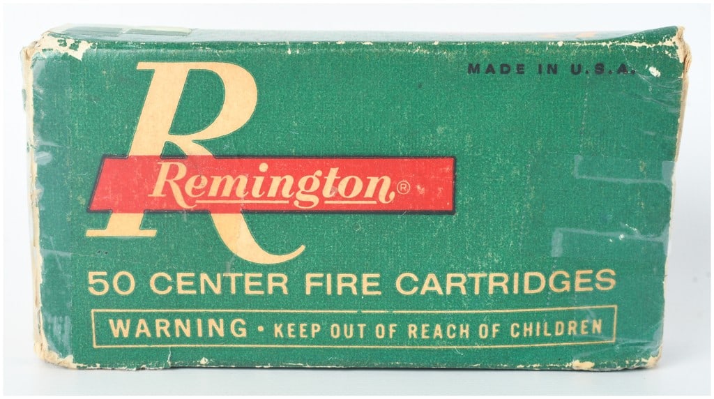 A Lot of 21 Remington .32 S&W Centerfire Cartridges: A lot of 21 Remington .32 S&W centerfire cartridges presented in a partial original green, red, and yellow cardboard box. These cartridges feature brass cases with silver-tone primers and 88 grain lea