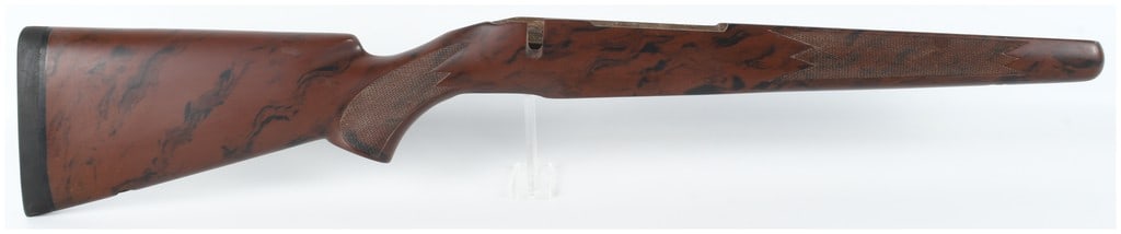 A Bolt-Action Wooden Stock with Marbled Brown and Black Finish: A sporting style wooden stock designed for a bolt-action rifle, featuring a distinctive marbled brown and black finish. The stock is configured with a Monte Carlo cheekpiece on the left side and incor