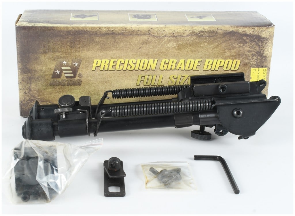An NcSTAR Precision Grade Full Size Bipod with Mounting Accessories: An NcSTAR Precision Grade full size bipod designed for rifle stabilization, featuring a metal construction with a black finish and spring-tensioned extendable legs. The bipod utilizes a Harris-style d