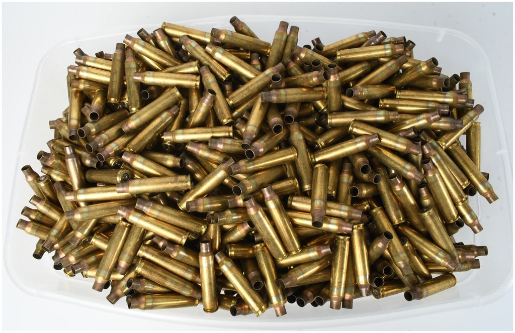 1,000 Mixed .223 Remington and 5.56x45mm NATO Brass Cartridge Casings: A collection of 1,000 spent brass cartridge casings in .223 Remington and 5.56x45mm NATO caliber. These bottlenecked cases exhibit visible annealing heat treatment marks around the shoulders and necks