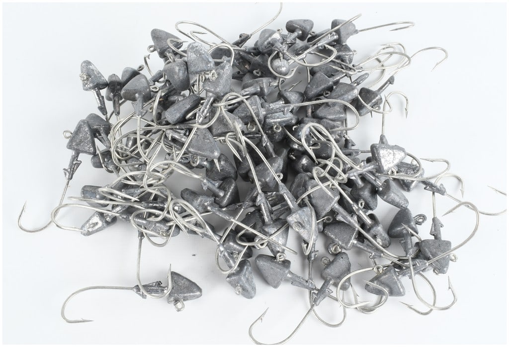 A Collection of 105 Triangular Lead Fishing Jig Heads: This collection contains 105 unpainted lead fishing jig heads. Each jig head features a triangular or darter style profile with a top-mounted line tie eyelet. The design includes a barbed bait keeper 