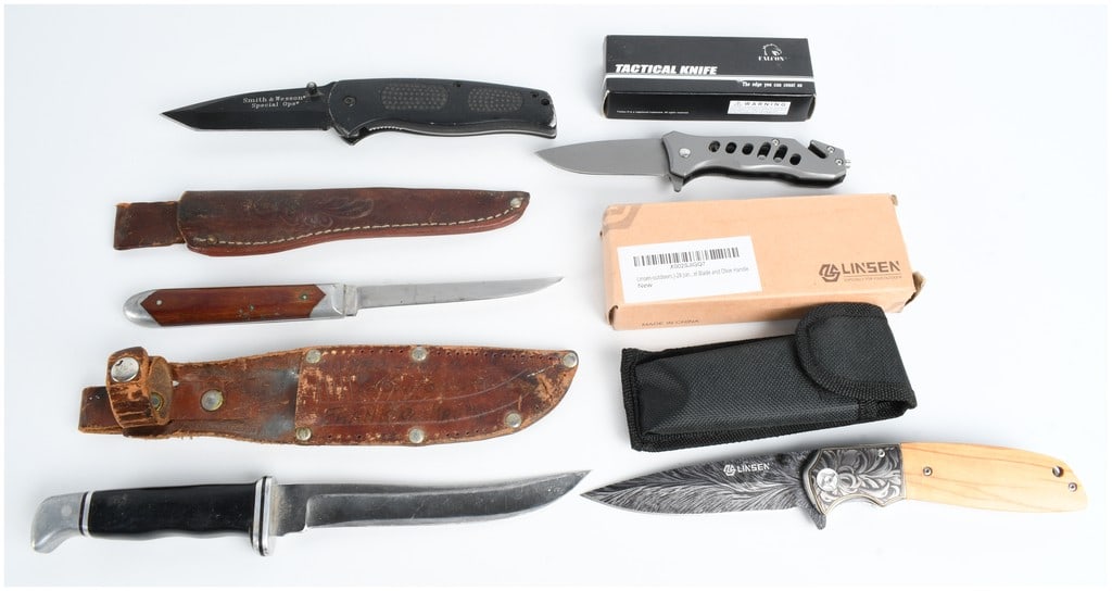 A Collection of Five Knives Including Buck and Smith & Wesson Models: This assortment of five knives includes a variety of styles for outdoor and tactical use. The set features a Linsen folding knife with an olive wood handle, etched floral-patterned bolsters, and a pat
