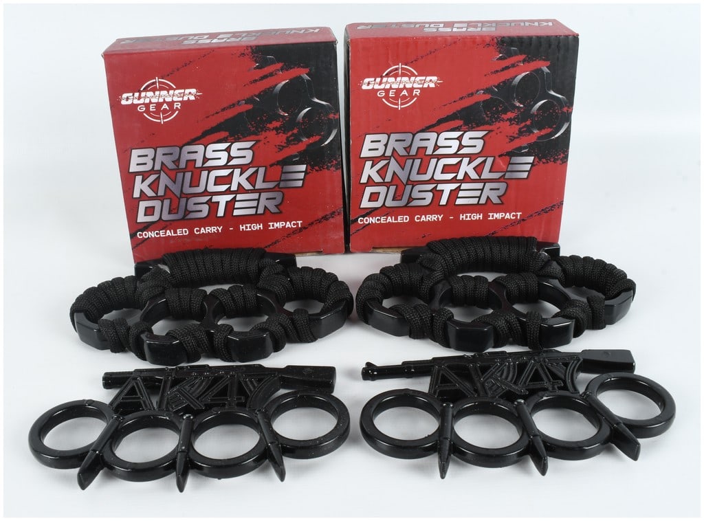 Four Boxes of Gunner Gear Brass Knuckle Dusters: This lot features four boxes of brass knuckles manufactured by Gunner Gear. The collection includes two distinct styles of four-finger knuckle dusters. One pair is constructed of metal with a matte