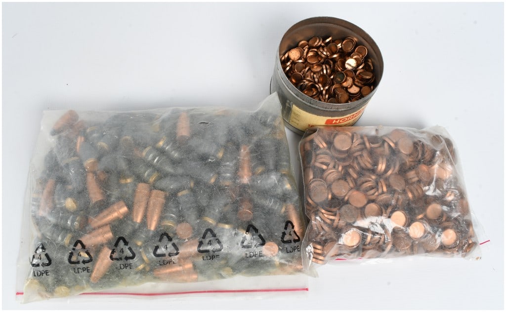 A Lot of Reloading Components Including 222 Bullet Tips with Hornady Gas Checks: A lot of reloading components featuring exactly 222 bullet tips and associated copper gas checks. The lot includes a clear plastic bag containing the 222 bullet tips, which are a mix of cast lead bull