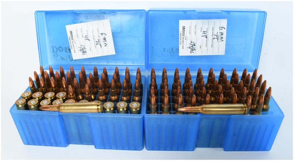 A Lot of 83 Cartridges and 14 Empty Casings of Remington and Winchester 6mm Remington Ammunition: This lot comprises a collection of 83 live cartridges and 14 empty casings of 6mm Remington ammunition, presented in two blue Midway plastic storage boxes. The ammunition appears to be handloaded, as 