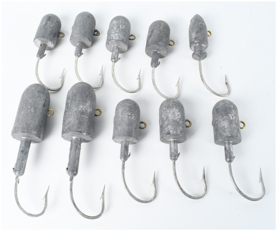 Ten Fishing Jig Heads with Embedded Lead Weights: This lot comprises 10 heavy-duty fishing jig heads designed for saltwater applications. Each assembly features a cast lead weight in either a bullet-nose or cylindrical shape. The lead weights are