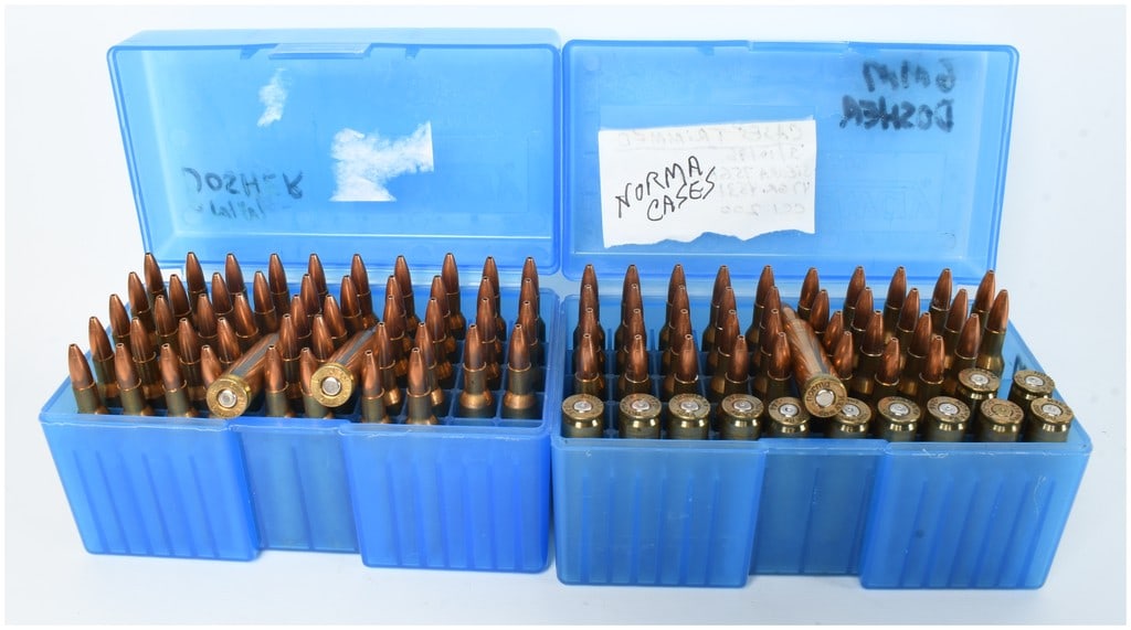 A Lot of 100 6mm Remington Cartridges and Casings: This lot consists of 100 components for 6mm Remington, comprising 88 live rounds and 12 empty brass casings. These appear to be handloaded cartridges stored in two blue plastic ammunition cases. The a