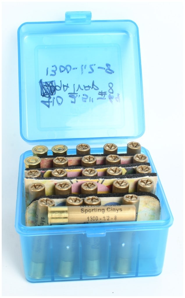 A Lot of 25 Remington Nitro Gold Sporting Clays 12 Gauge Shotshells: This lot consists of 25 Remington Nitro Gold Sporting Clays 12 gauge target shotshells. The ammunition is housed in a blue plastic flip-top storage box featuring handmade dividers constructed from foa