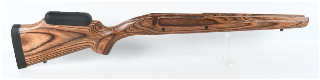 Winchester Model 70 Long Action Blino Laminated Wood Rifle Stock with Cheek Riser: A laminated wood rifle stock designed for a Winchester Model 70 long action bolt-action firearm. The stock features a Blino pattern with a brown and black layered grain and is equipped with a black ru