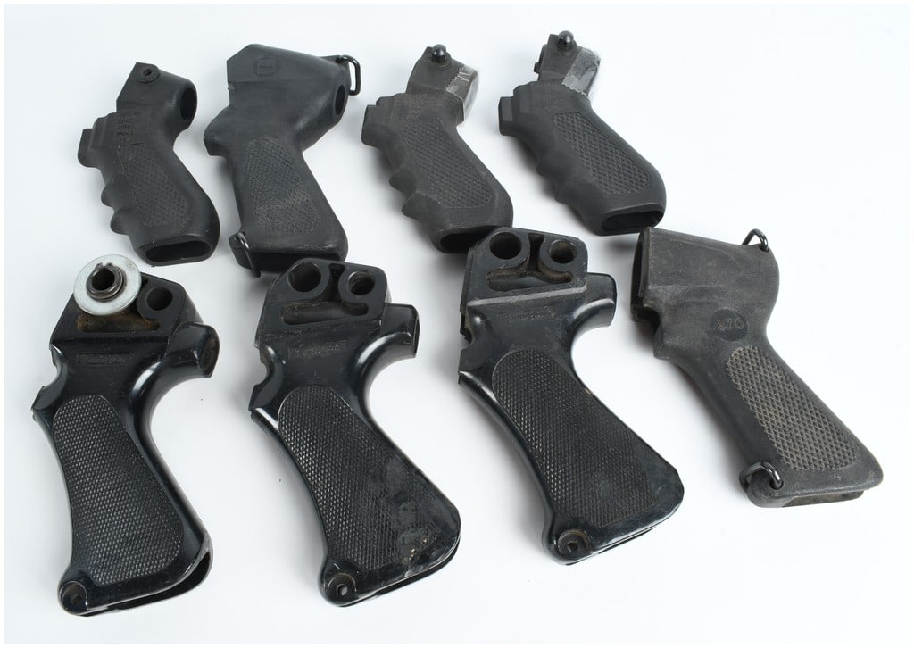 A Collection of 8 Remington and Winchester Compatible Shotgun Pistol Grips: This lot features a collection of 8 black polymer pistol grips designed for various shotgun platforms. The assembly includes four grips in a matte finish and four grips with a glossy or semi-matte fin