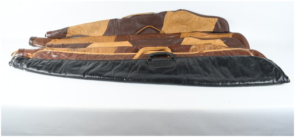 A Collection of Six Vintage Leather and Faux Leather Soft Gun Cases: An assortment of six vintage soft-sided gun cases or slips designed for the transport and storage of rifles or shotguns. The collection includes examples with a two-tone brown and tan paneled construc