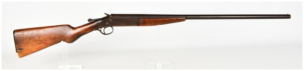 T. Barker Single Shot Break Action Shotgun with 28 Inch Barrel: This T. Barker single-shot, break-action shotgun is a classic utility firearm featuring a 28-inch barrel, an external hammer, and a top-lever release mechanism. The barrel and receiver show a consiste