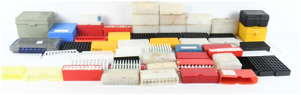 A Lot of 52 Ammunition Storage Boxes and Reloading Accessories: This lot consists of a collection of 52 ammunition storage boxes and reloading accessories, primarily constructed of durable plastic in various colors including red, blue, yellow, gray, black, and tra