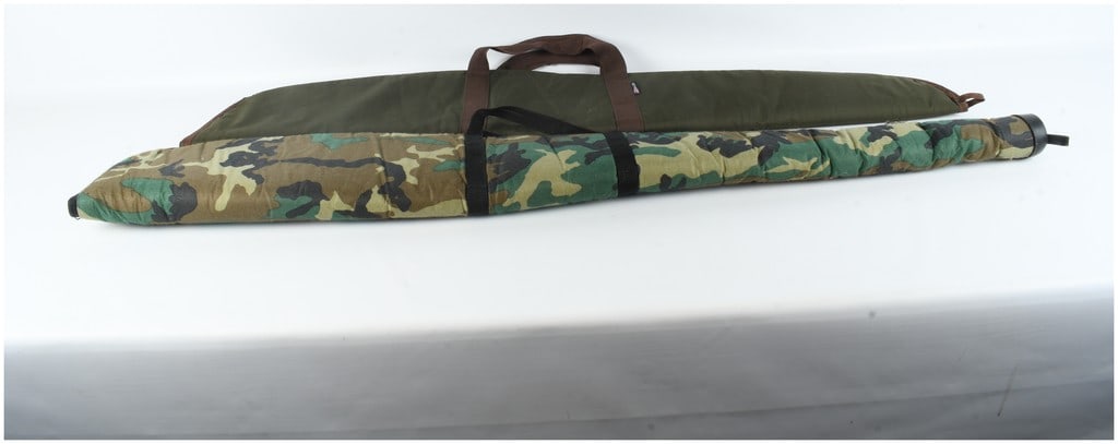 Two Allen Company Padded Rifle Cases: Two padded soft-sided long gun cases manufactured by the Allen Company. The first case is finished in a woodland camouflage pattern fabric with black webbing carry handles and a reinforced black plast