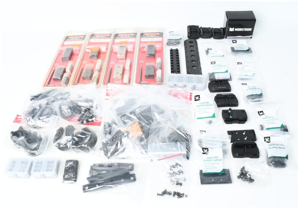 A Collection of Firearm Optic Mounting Adapters and Tactical Hardware Components Including Redfield,: This lot consists of a large assortment of firearm optic mounting accessories and tactical hardware from manufacturers including Redfield, Vortex Optics, and Monstrum. Included are four retail-package