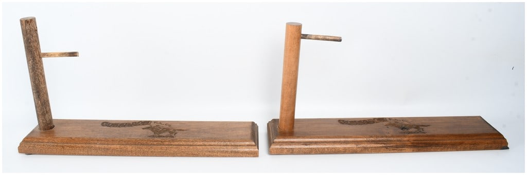 A Pair of Cimarron Firearms Co. Wooden Pistol Display Stands: This lot features a pair of wooden handgun display stands produced by Cimarron Firearms Co., specifically designed for the presentation of western-style revolvers and other pistols. Each stand is