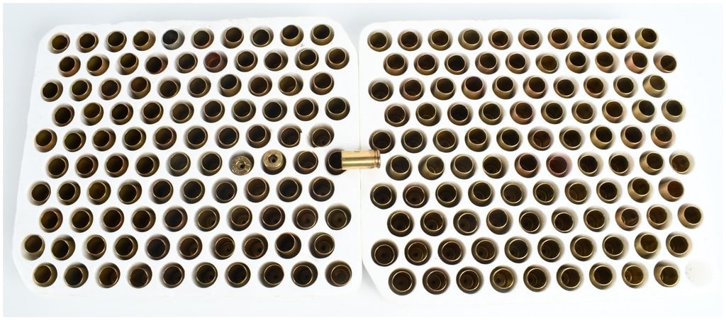 200 Pieces of 9mm Luger Spent Brass Shell Casings: A collection of 200 spent brass shell casings, primarily 9mm Luger caliber, organized within two white styrofoam trays. Visual inspection of the headstamps identifies markings from manufacturers inclu
