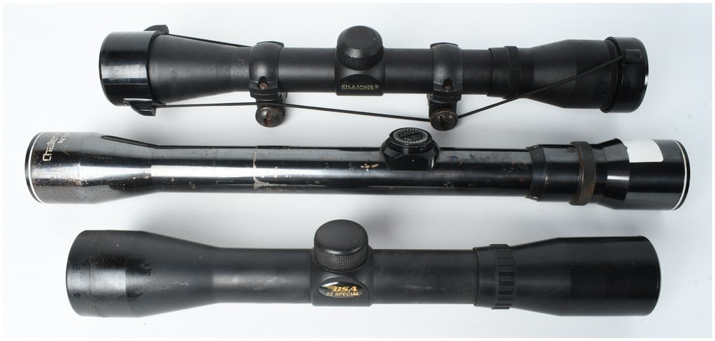 Three Rifle Scopes Including BSA .22 Special, Challenger USA by Weaver, and Simmons Model 1022: A collection of three sporting rifle scopes. The first optic is a Simmons Model 1022 scope featuring a matte black finish, standard duplex reticle, integral mounting rings on a rail, and elasticized p
