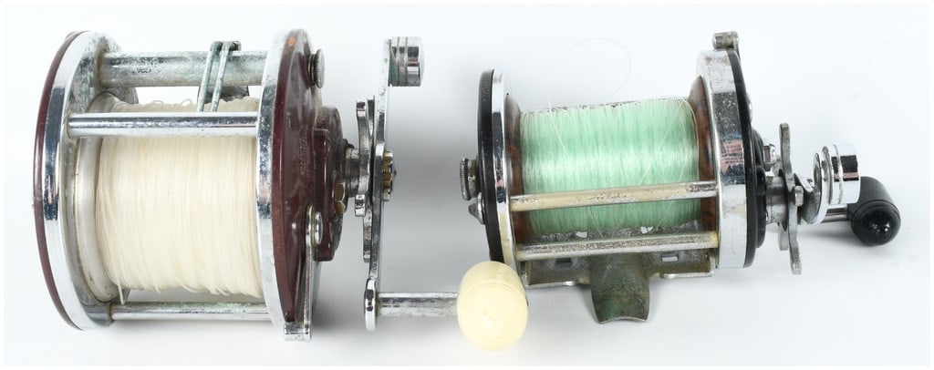 Two Vintage Penn Peer No. 309 and Surfmaster No. 200 Fishing Reels: A pair of vintage conventional fishing reels manufactured by the Penn Fishing Tackle Mfg. Co. of Philadelphia, Pennsylvania. The first reel is a Penn Peer No. 309, featuring maroon bakelite side plate