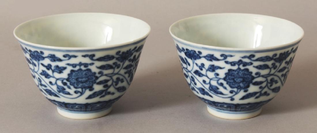 A PAIR OF CHINESE MING STYLE BLUE & WHITE PORCELAIN: A PAIR OF CHINESE MING STYLE BLUE & WHITE PORCELAIN TEABOWLS, decorated with formal scrolling flowerheads, each base with a six-character Yongzheng mark, 3.3in diameter & 2.2in high.