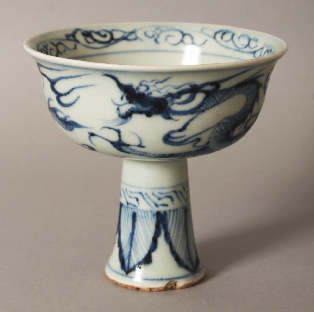 A CHINESE MING STYLE BLUE & WHITE PORCELAIN STEM BOWL,: A CHINESE MING STYLE BLUE & WHITE PORCELAIN STEM BOWL, the sides decorated with a dragon pursuing a flaming pearl, 3.8in diameter at rim & 3.6in high.