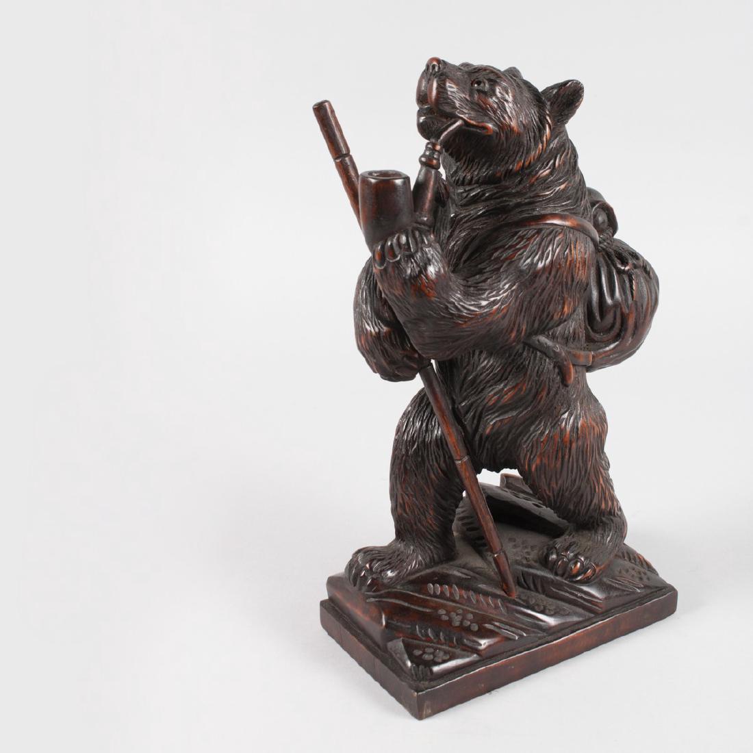 A GOOD CARVED WOOD BLACK FOREST STANDING CLIMBING BEAR: A GOOD CARVED WOOD BLACK FOREST STANDING CLIMBING BEAR with stick, pipe in his mouth and bag on his back. 12ins high.