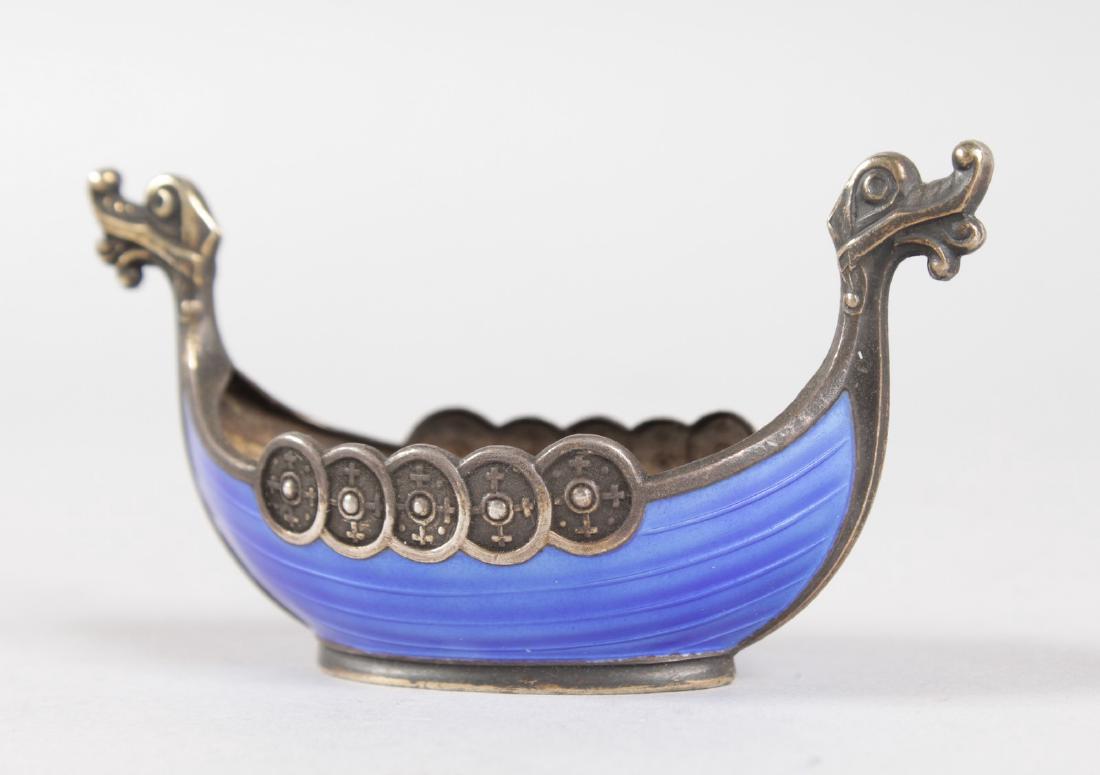 A SMALL NORWEGIAN STERLING SILVER AND BLUE ENAMEL: A SMALL NORWEGIAN STERLING SILVER AND BLUE ENAMEL VIKING SHIP SALT, stamped 925 S. STERLING NORWAY. 3.25ins long.