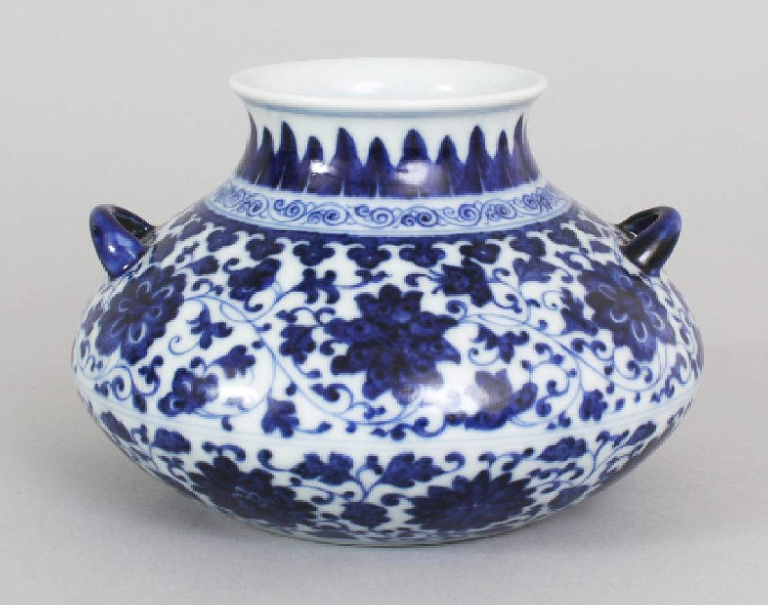 A CHINESE MING STYLE BLUE & WHITE PORCELAIN VASE, of: A CHINESE MING STYLE BLUE & WHITE PORCELAIN VASE, of unusual squat form, the sides decorated with formal scrolling foliage, the base with a Qianlong seal mark, 5.4in wide at widest point & 3.6in high.