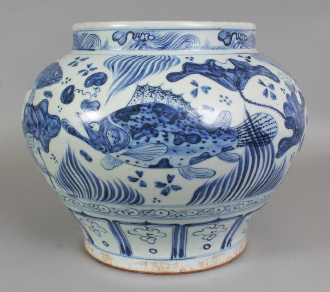 A LARGE CHINESE YUAN STYLE BLUE & WHITE PORCELAIN JAR,: A LARGE CHINESE YUAN STYLE BLUE & WHITE PORCELAIN JAR, decorated with carp swimming amidst water weeds, the base unglazed, 12.7in wide at widest point & 10.4in high.