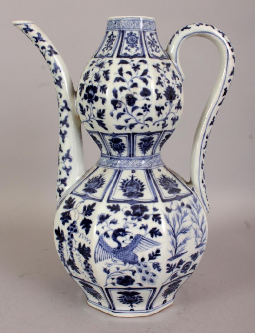 A GOOD QUALITY CHINESE YUAN STYLE BLUE & WHITE: A GOOD QUALITY CHINESE YUAN STYLE BLUE & WHITE PORCELAIN EWER, of octagonal section, the sides decorated with hanging vine, phoenix and foliage, the base unglazed, 10in long including handle and spout