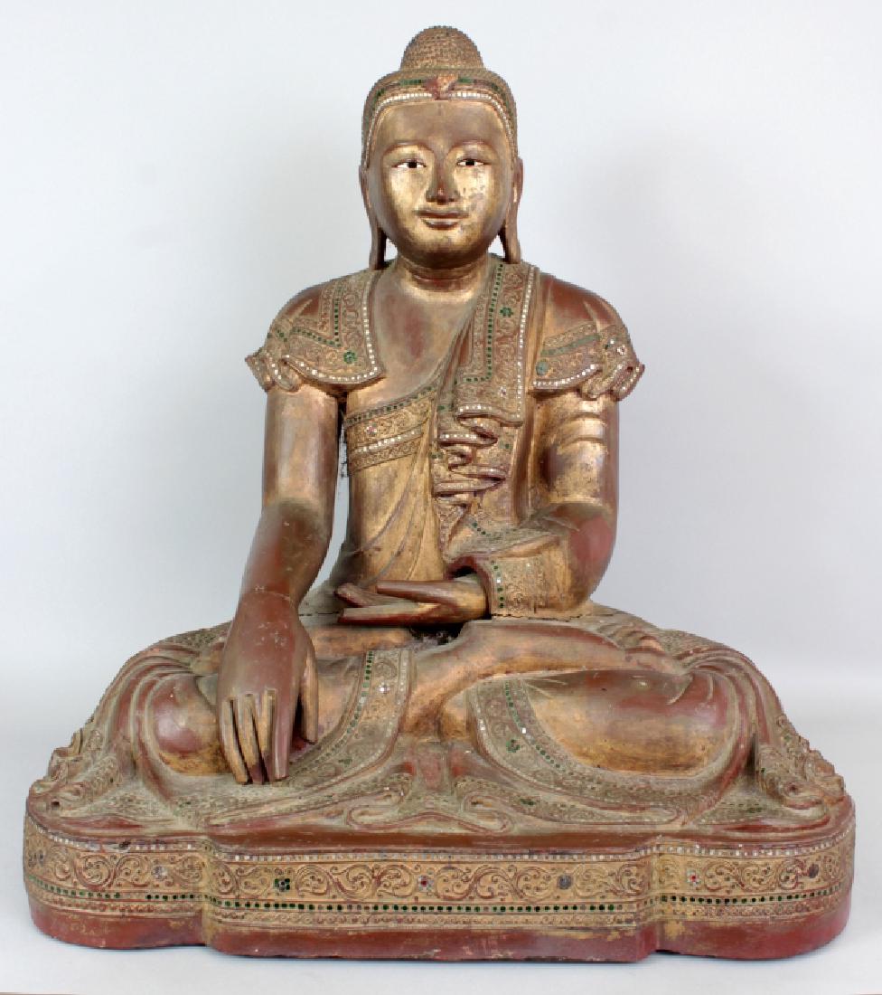 A VERY LARGE EARLY 20TH CENTURY BURMESE LACQUERED WOOD: A VERY LARGE EARLY 20TH CENTURY BURMESE LACQUERED WOOD FIGURE OF BUDDHA, seated in dhyanasana, the edges of his robes carved in relief with scrollwork and inset with glass borders, 26.5in wide at wide